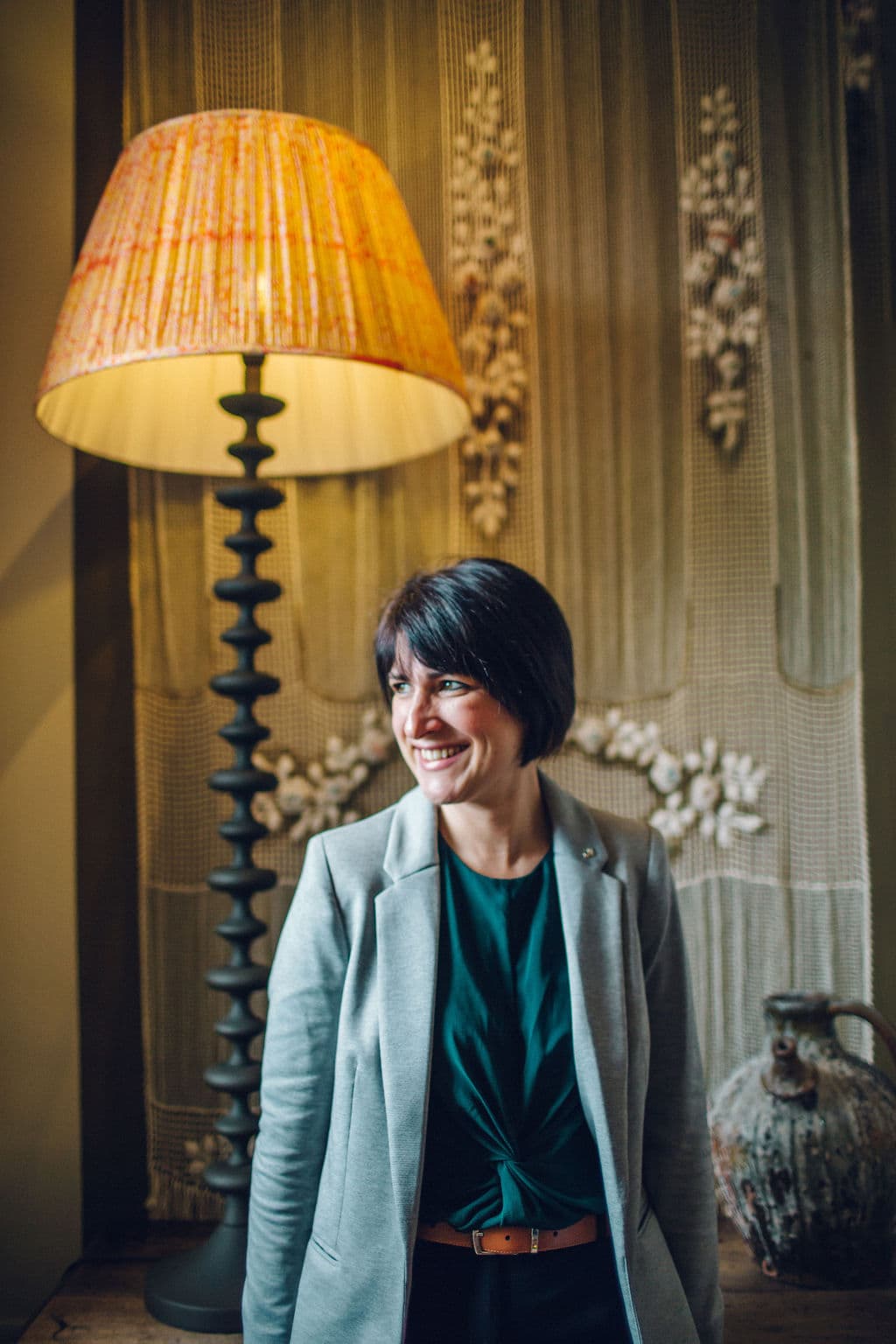 smiling lady next to a lamp