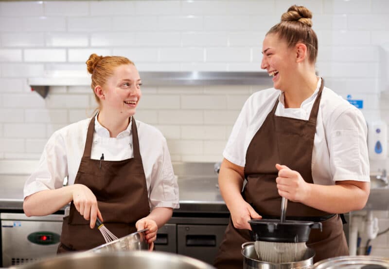smiling lady chefs preparing food in the kitchen